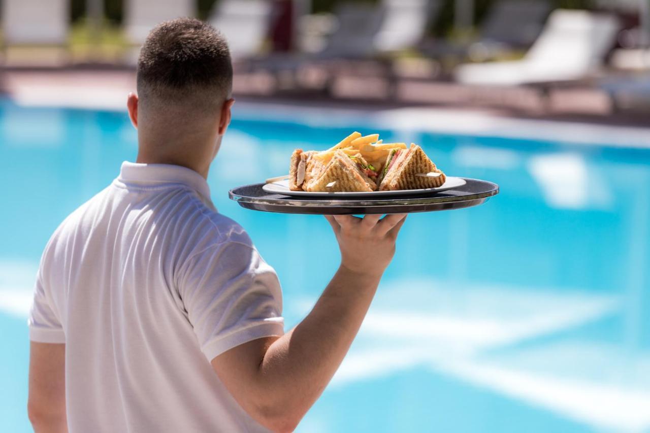 Hotel Du Lac Congress Center & Spa Ioannina Extérieur photo A waiter serving food